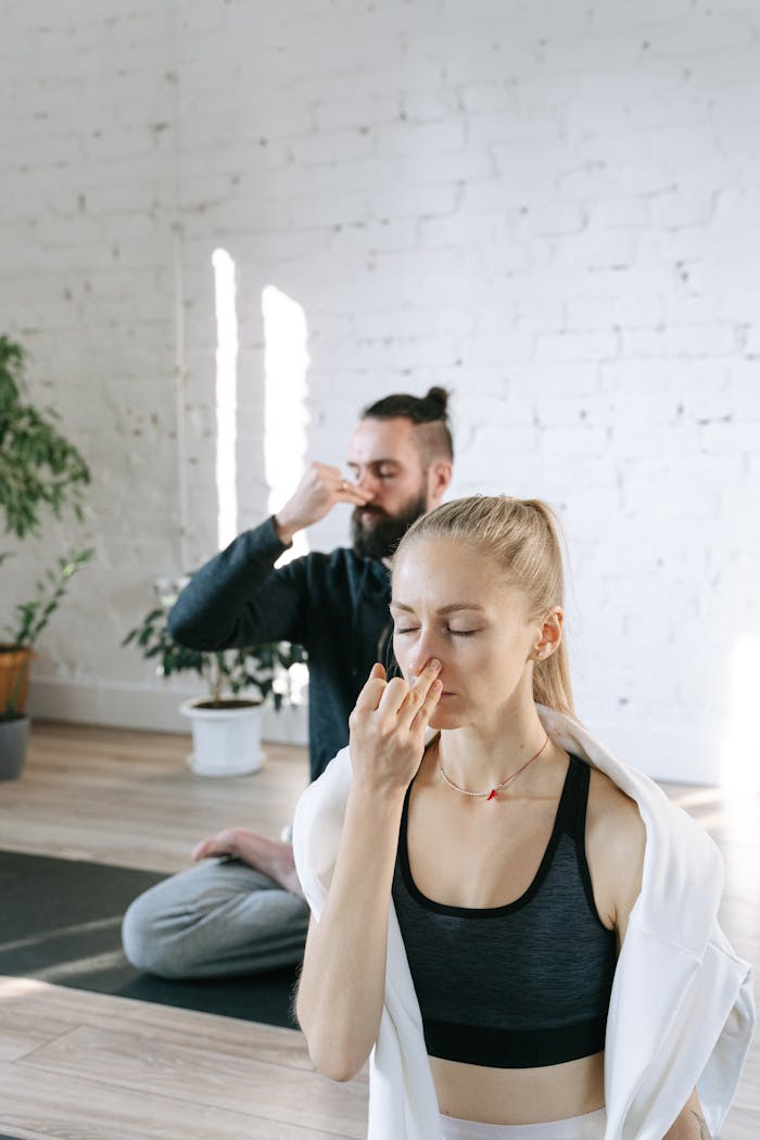 Crafting Captivating Headlines: Your awesome post title goes here A man and woman meditating and practicing yoga breathing indoors.