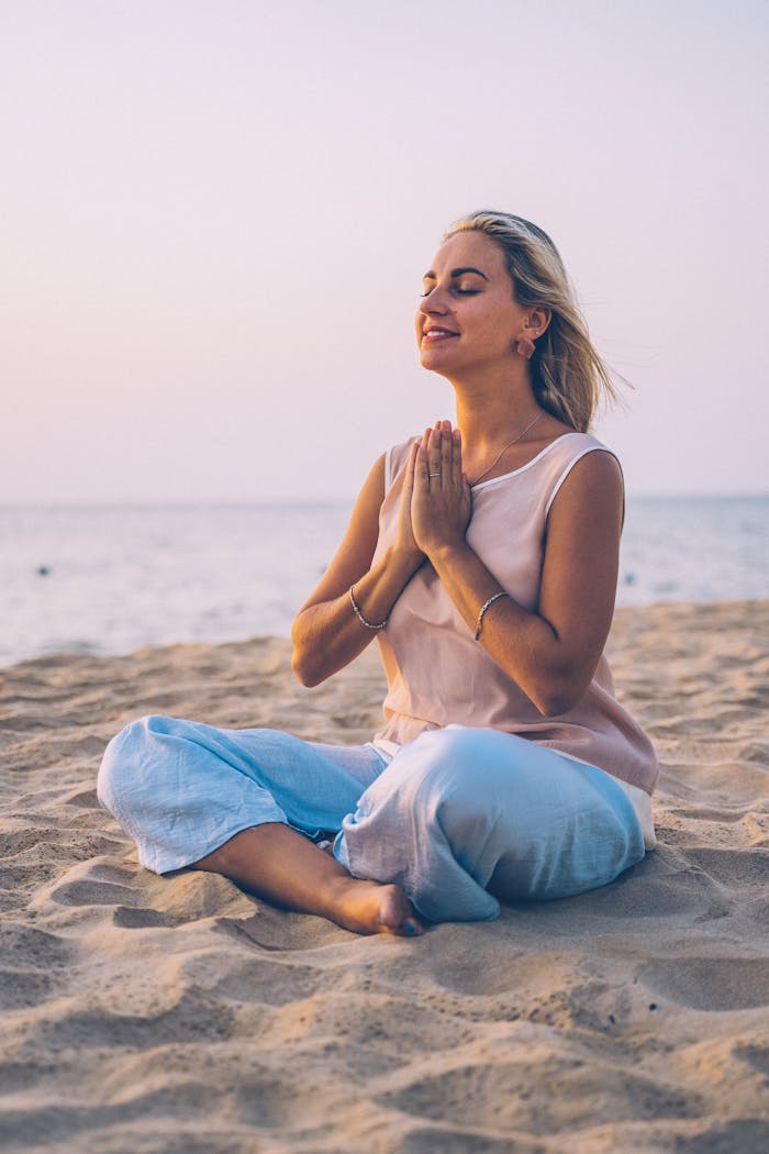 Mastering the First Impression: Your intriguing post title goes here Adult woman practicing meditation on a serene beach during sunset, exemplifying relaxation and mindfulness.